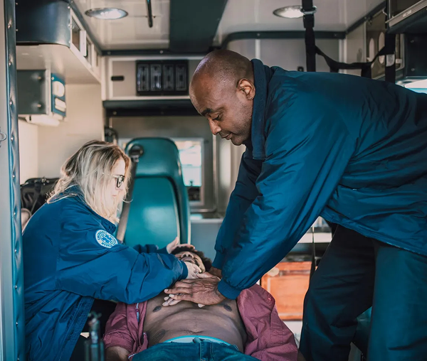 Paramedics performing CPR in an ambulance.