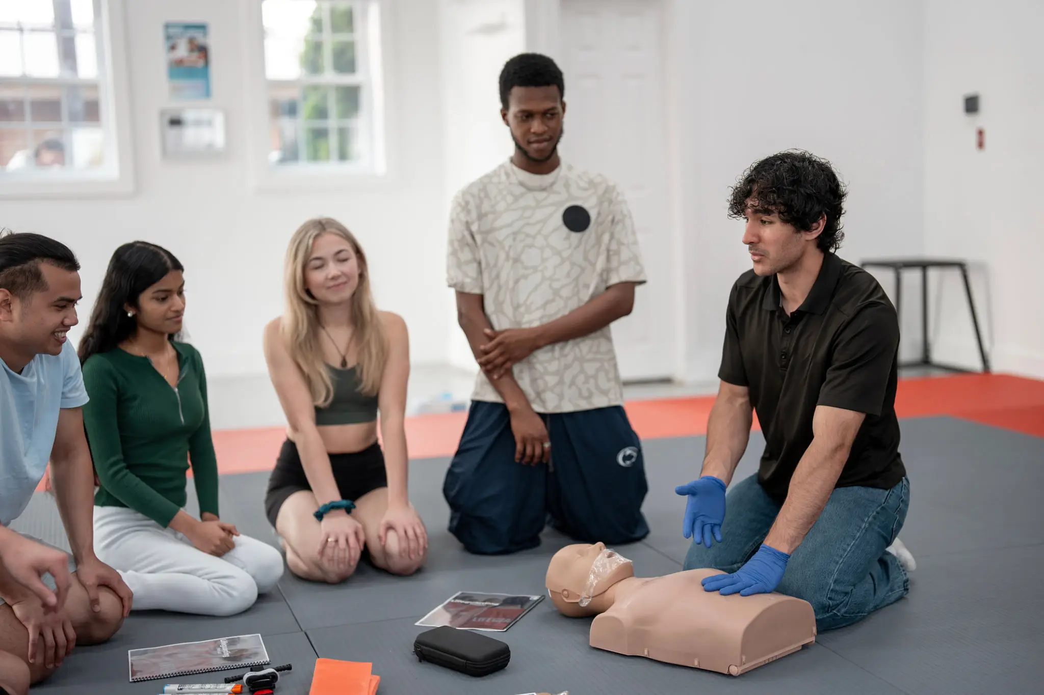 Group practicing CPR on a mannequin.